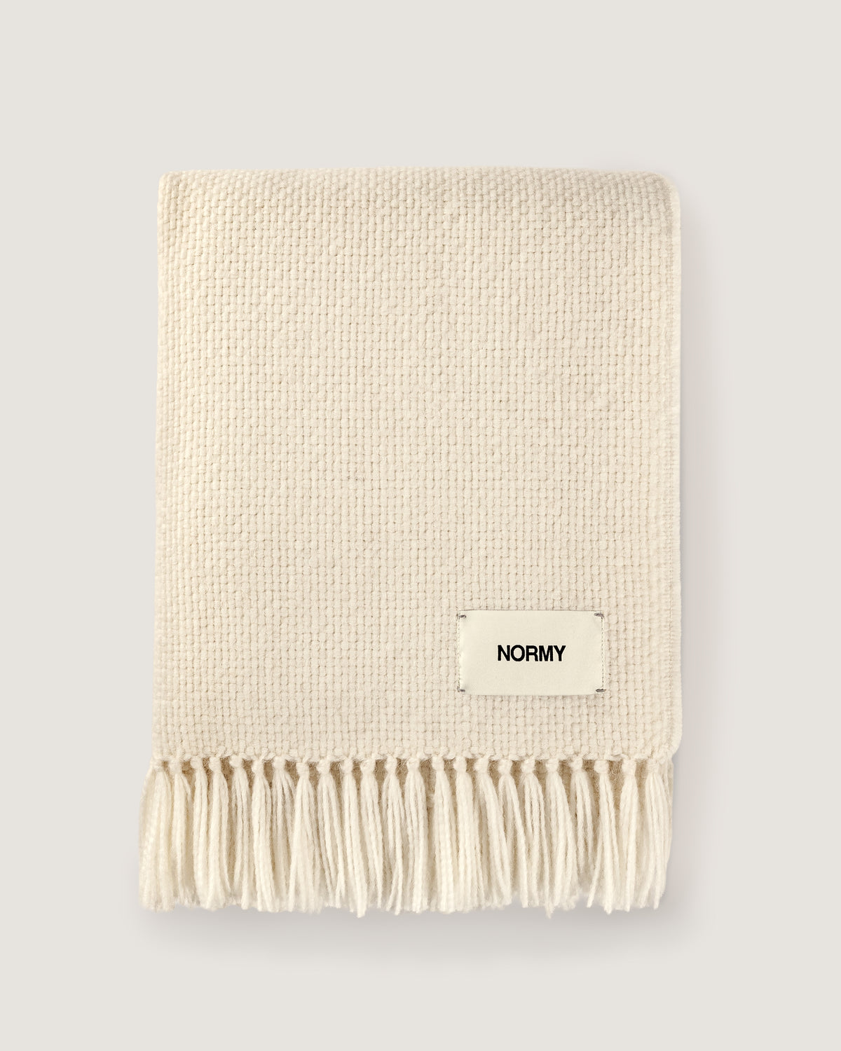 Normy Alpaca Blanket in moon with a small cream label reading NORMY, shown on a light gray background.