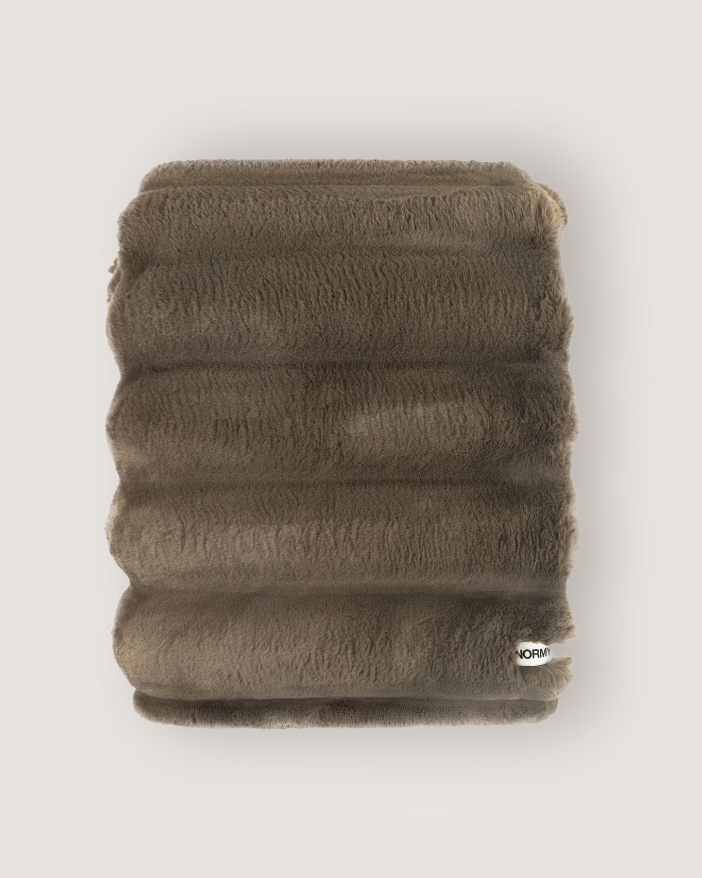 Dimensional faux fur blanket in fungi folded against a neutral background