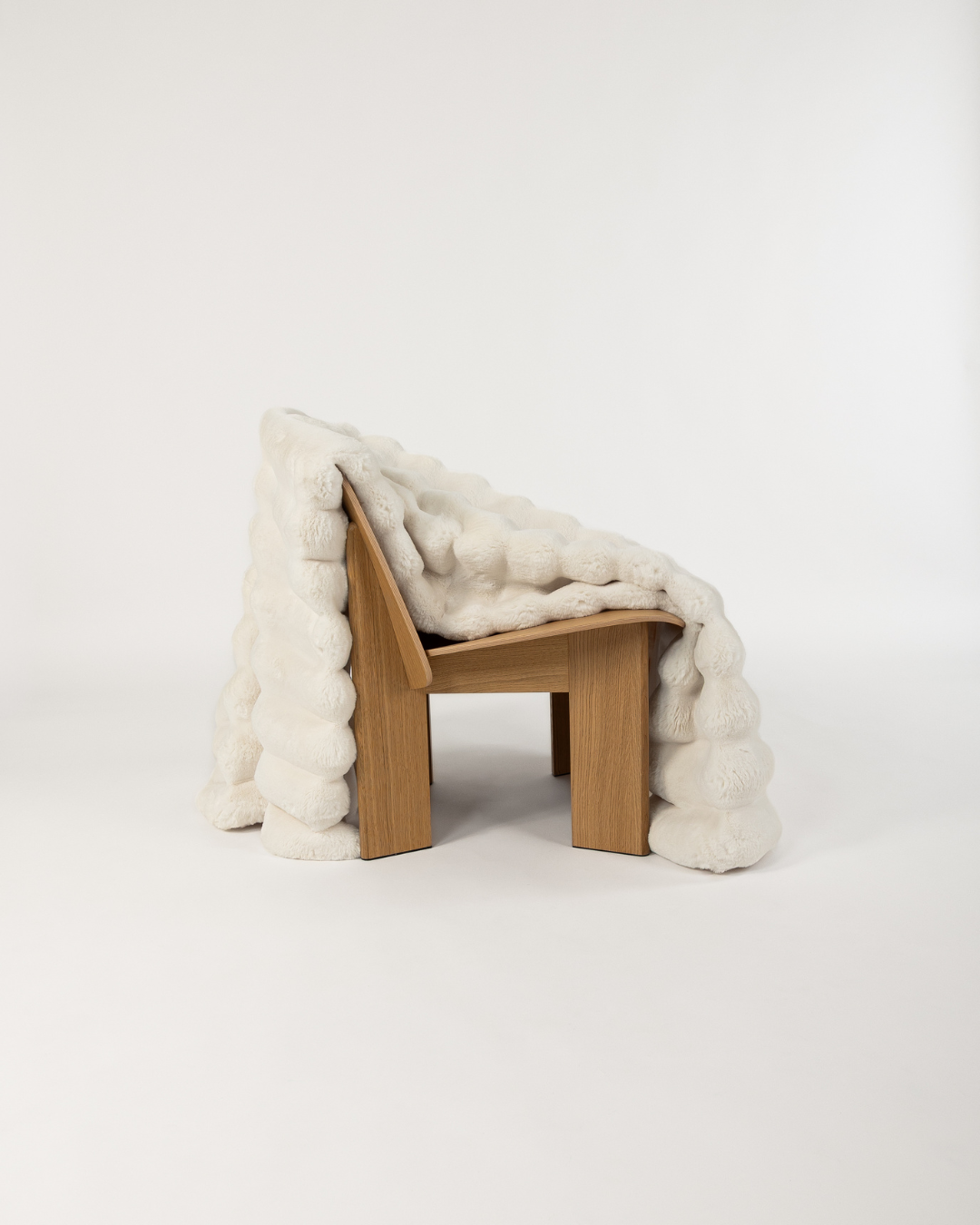 Dimensional faux fur blanket in moon draped on a wooden chair