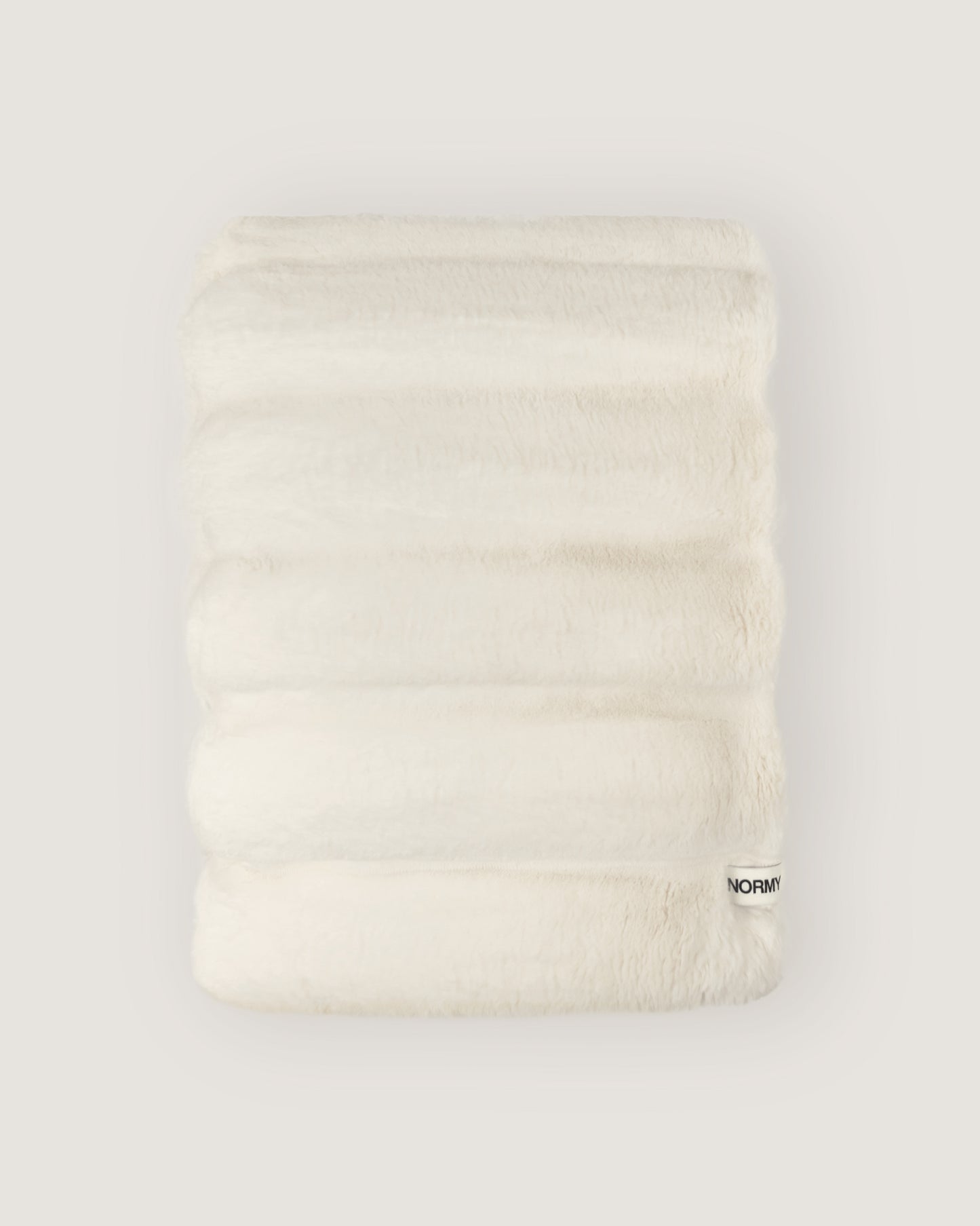 Dimensional faux fur blanket in moon folded against a neutral background