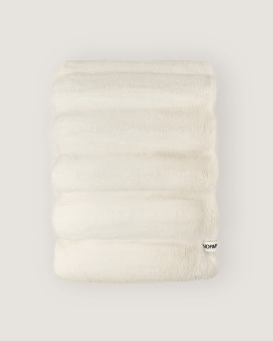 Dimensional faux fur blanket in moon folded against a neutral background