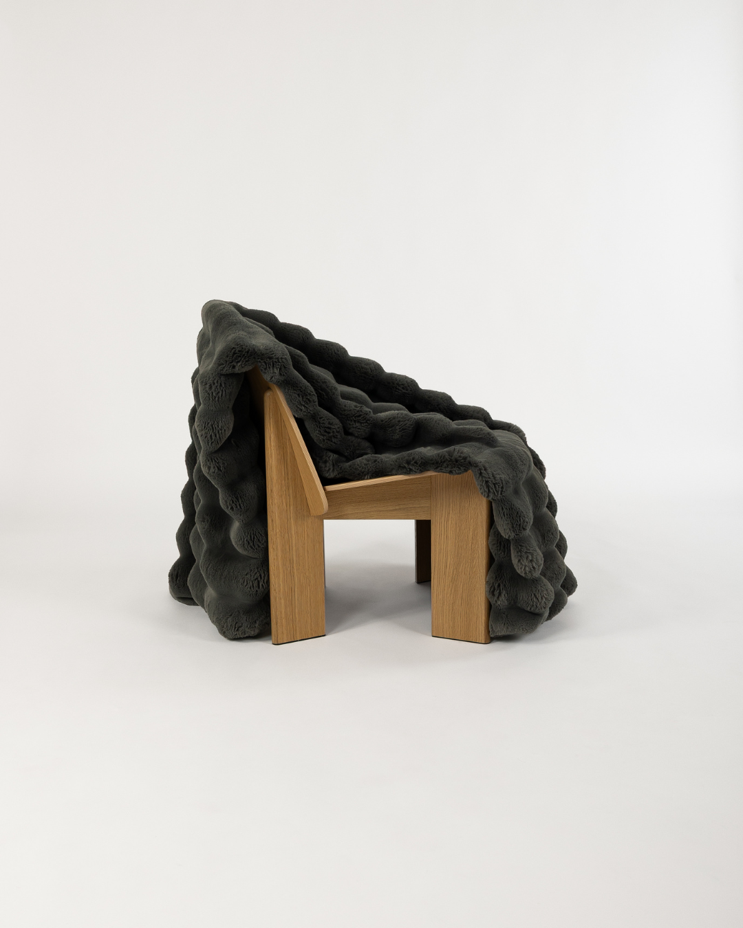 Dimensional faux fur blanket in peak draped on a wooden chair