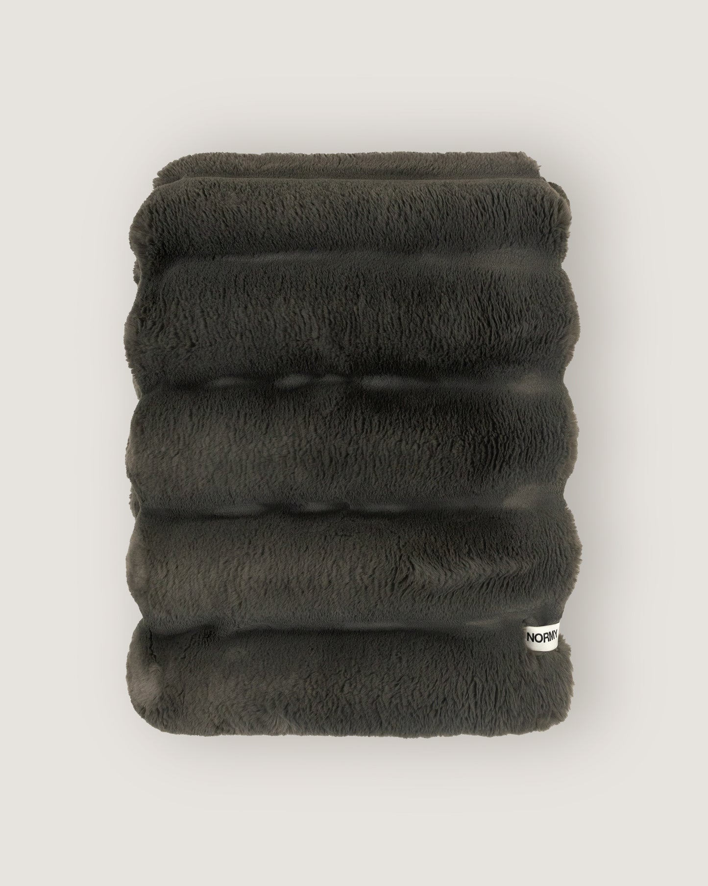 Dimensional faux fur blanket in peak folded against a neutral background