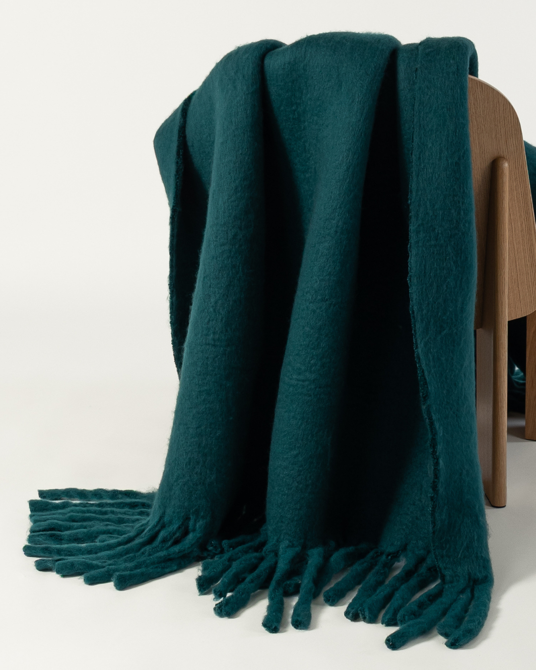 Faux mohair blanket in alpine draped on wooden chair