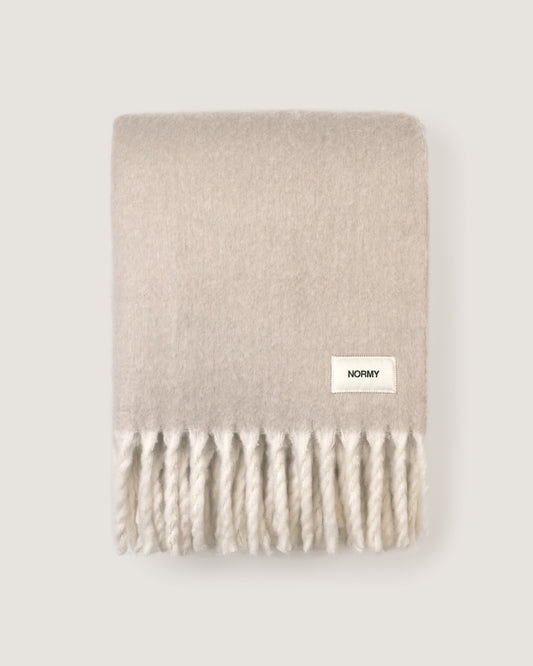 Faux mohair blanket in clay/moon folded against a neutral background