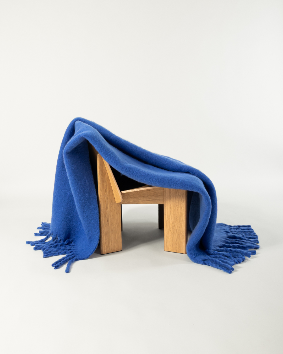 Faux mohair blanket in cobalt draped on wooden chair