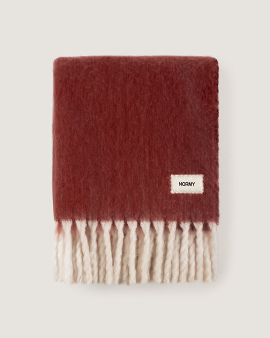 Faux mohair blanket in pomegranate/moon folded against a neutral background
