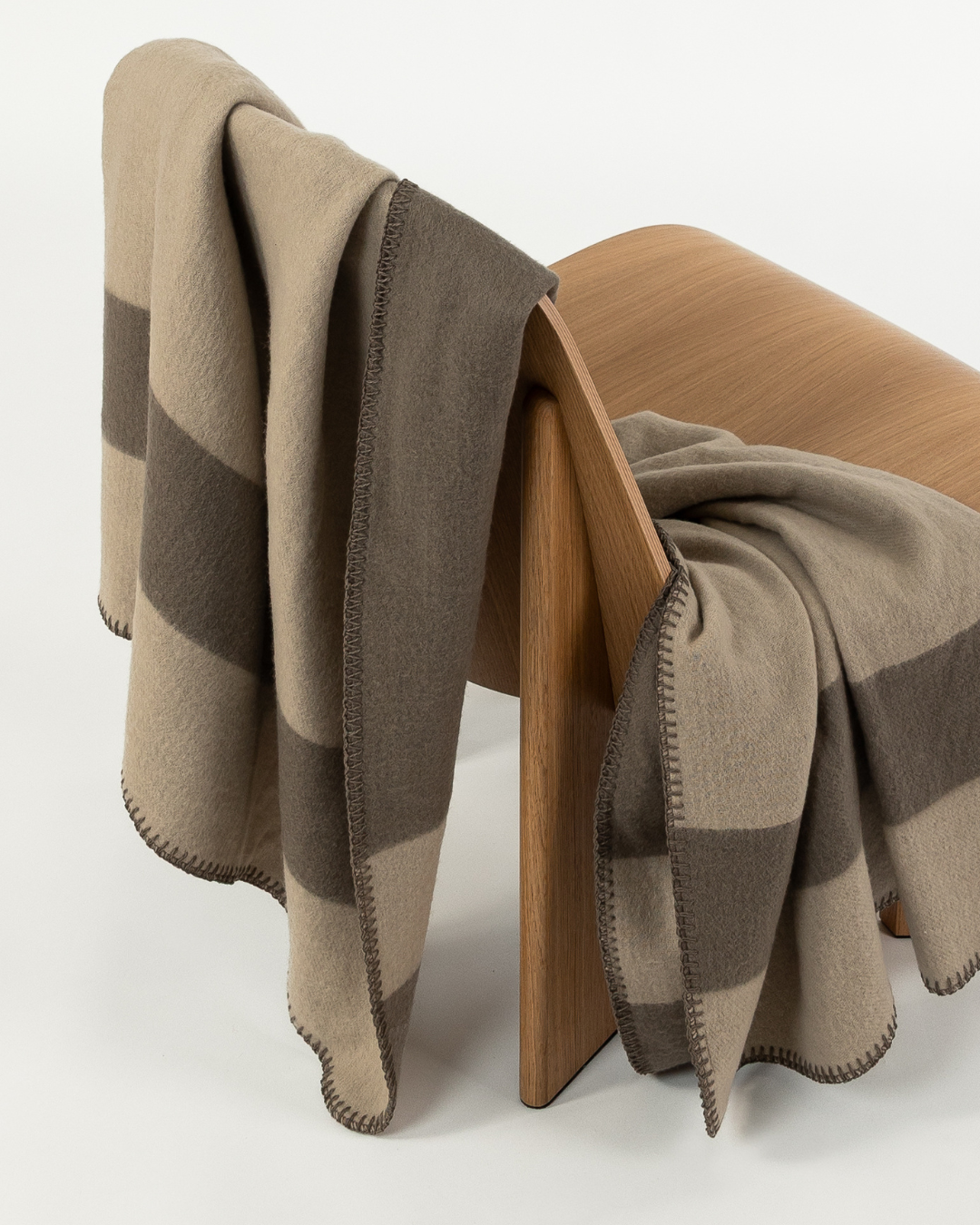 Merino wool blanket in clay/fungi draped over a wooden chair