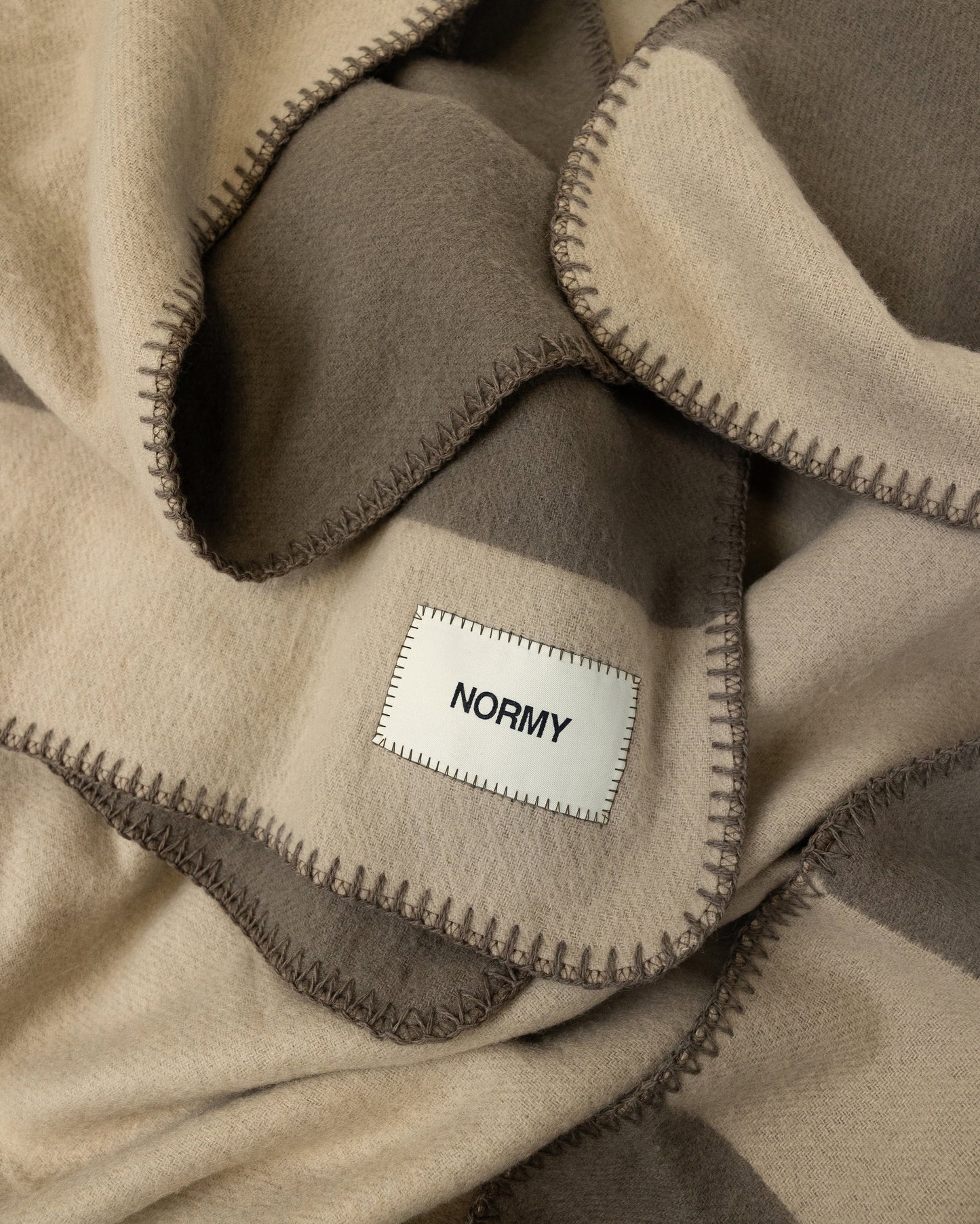 Close up fabric shot of a merino wool blanket in clay/fungi