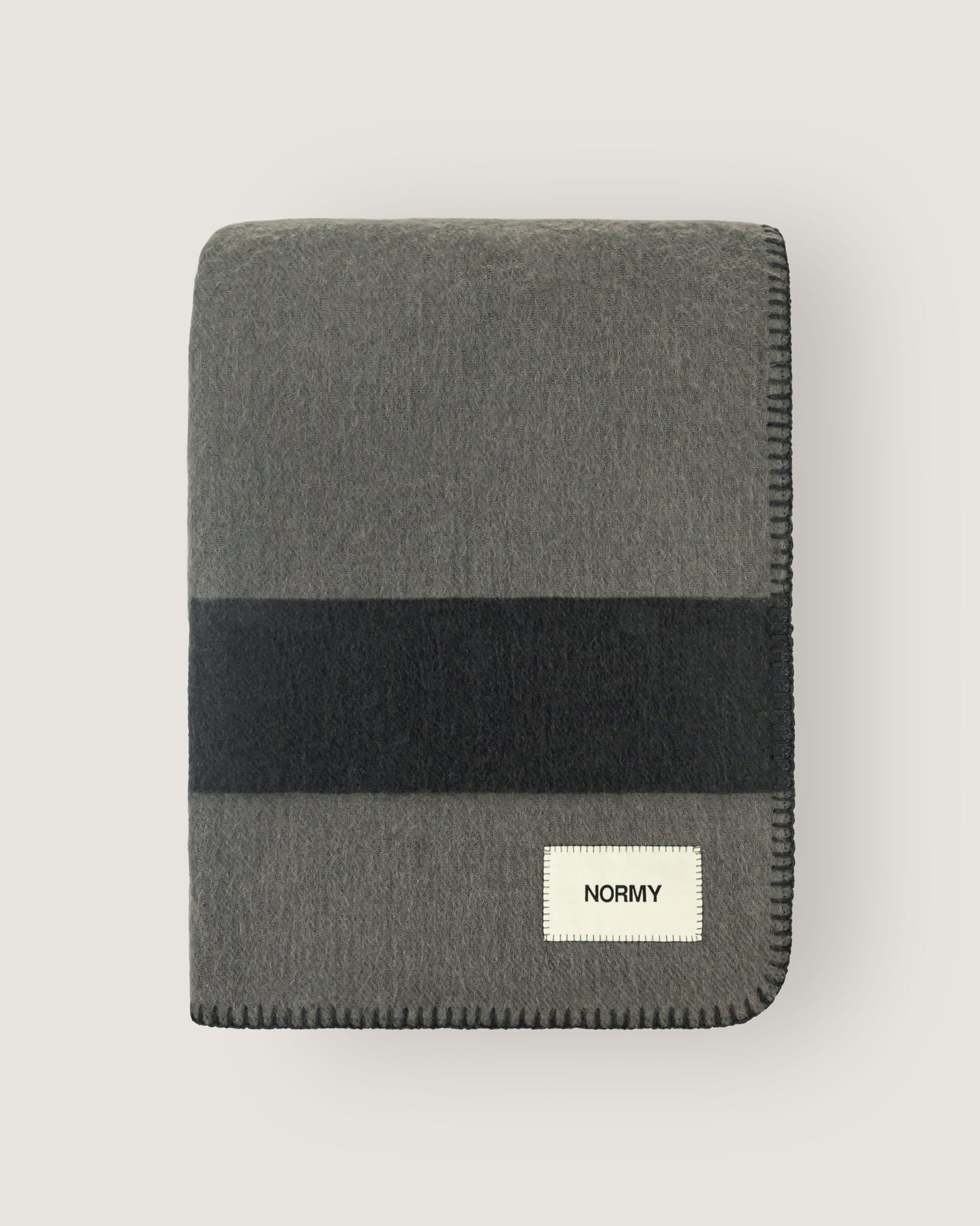 Merino wool blanket in peak/caviar folded against a neutral background