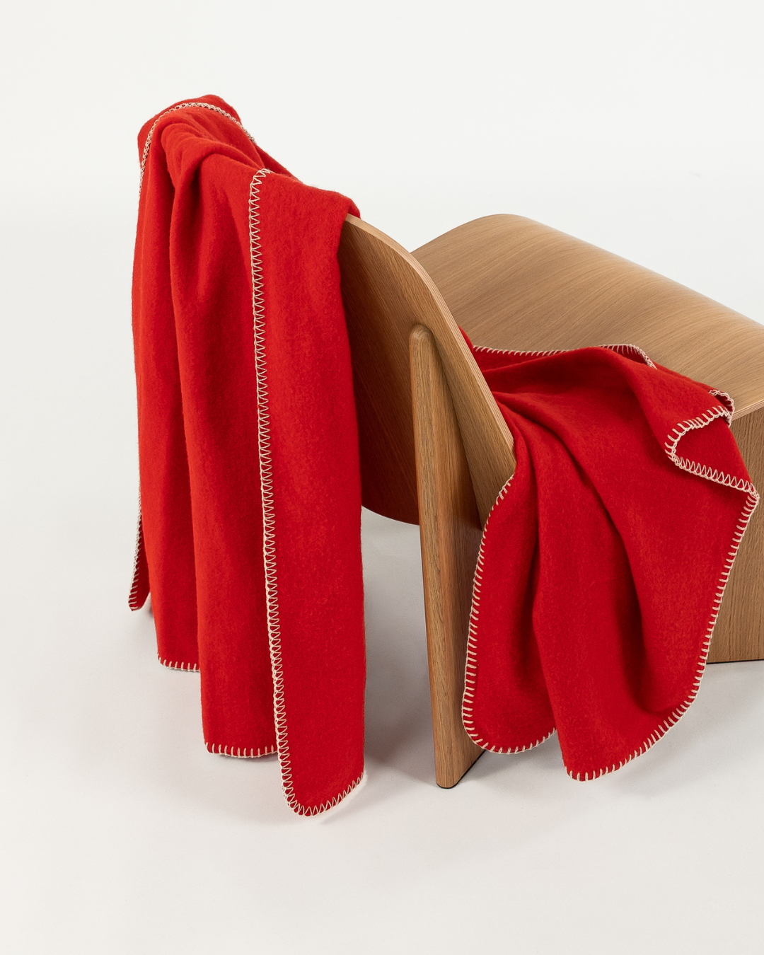 Merino wool blanket in poppy draped over a wooden chair