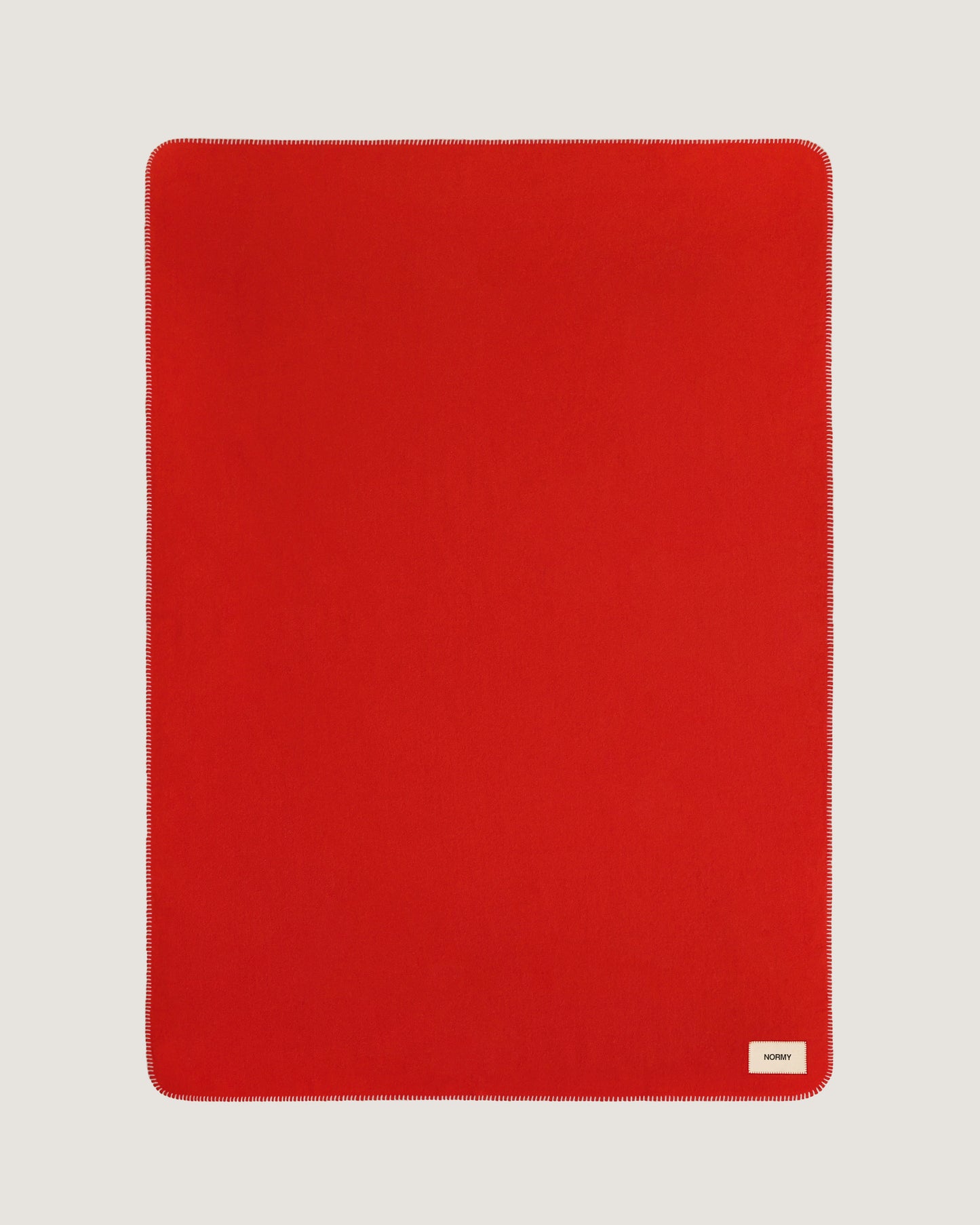 Merino wool blanket in poppy flat against a neutral background